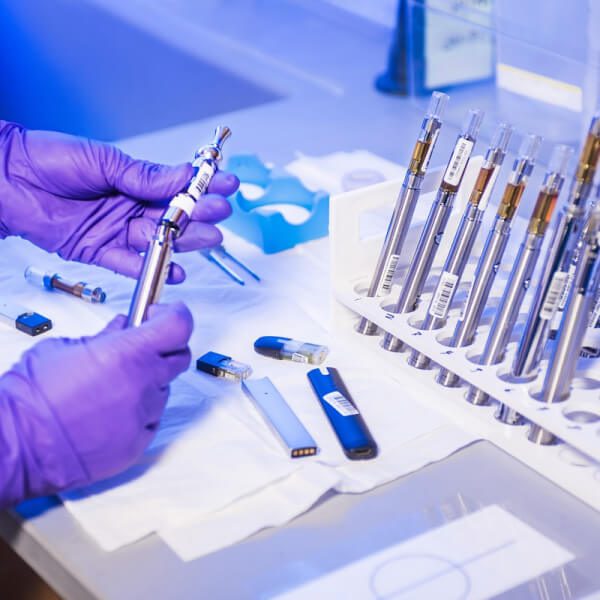 Gloved hands preparing insulin syringes on a medical workspace.