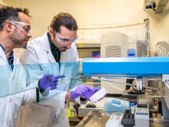 Scientists in a lab examining samples with advanced equipment.